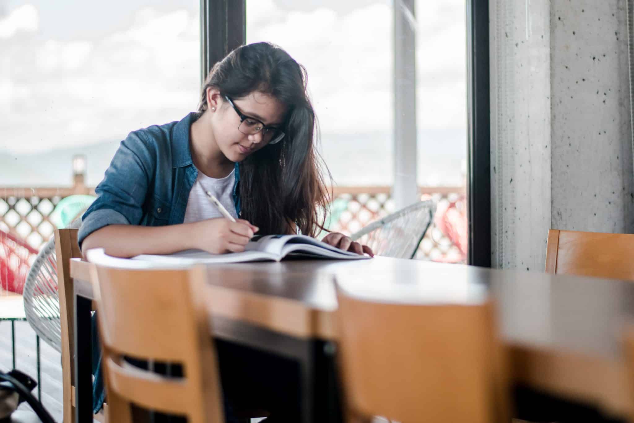 jeune femme apprend l'anglais en utilisant un cahier